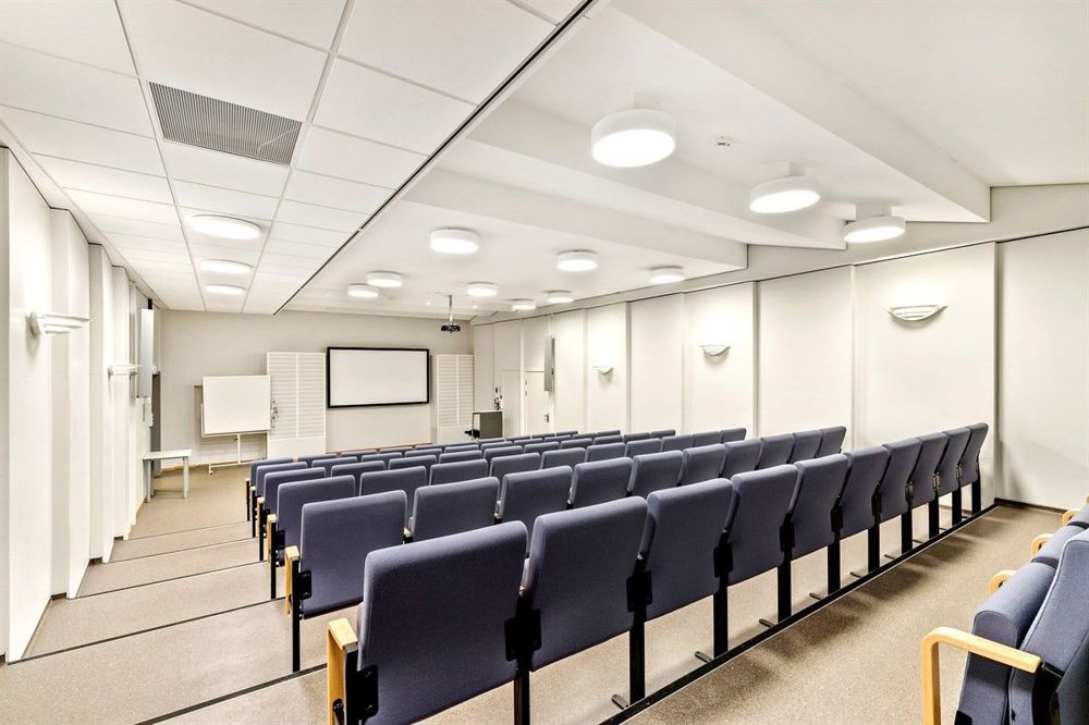 auditorium, blå stolrader, hvite vegger