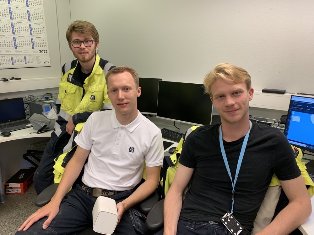 three male students sitting in chairs at their office space