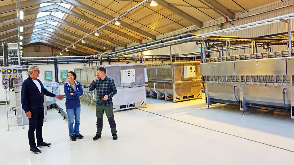tre personer, dialog, stor åpen hall, produksjonsutstyr.