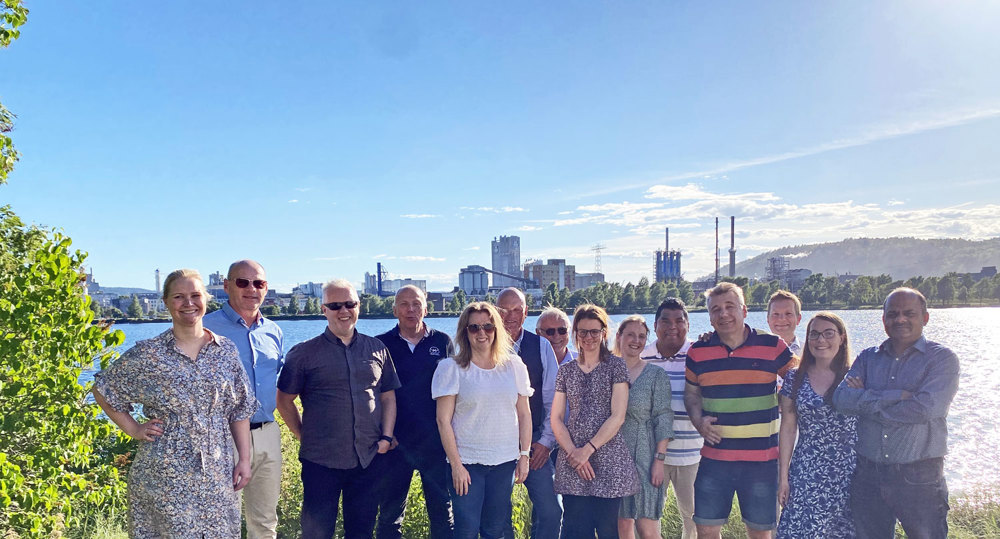 group photo, lake and industry behind