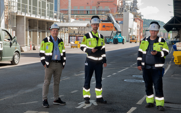 three men out in the street in industrial park, measuring 5G coverage