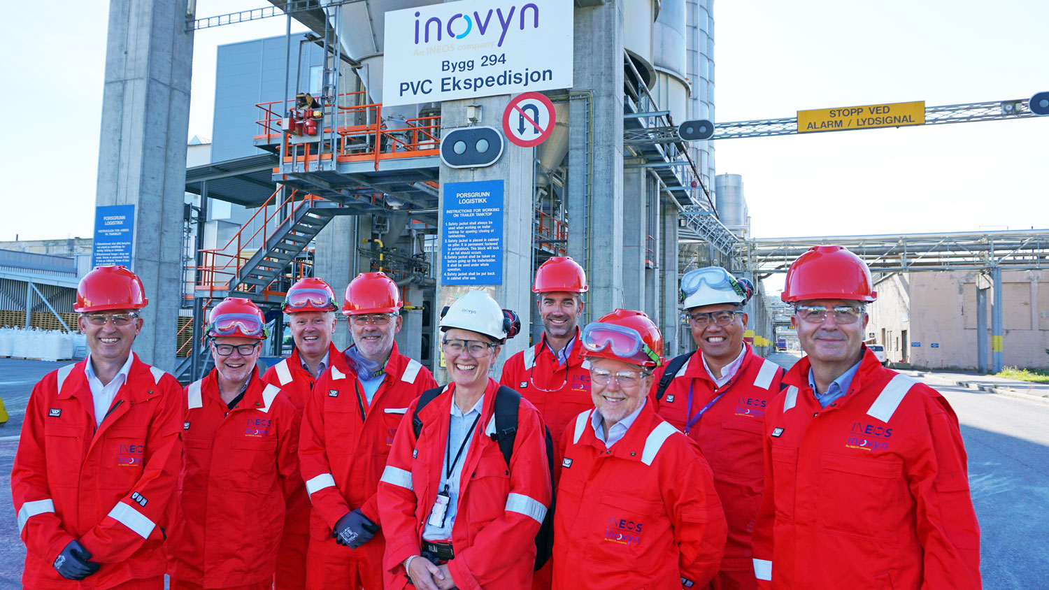 group photo of the Inovyn Group's management team, all dressed in red coats and red helmets.