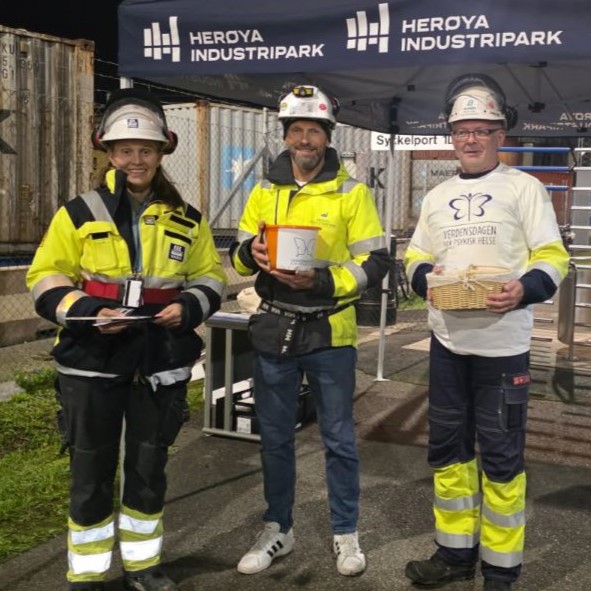 tre personer i verneutstyr, telttak, containere, rotasjonsgrind