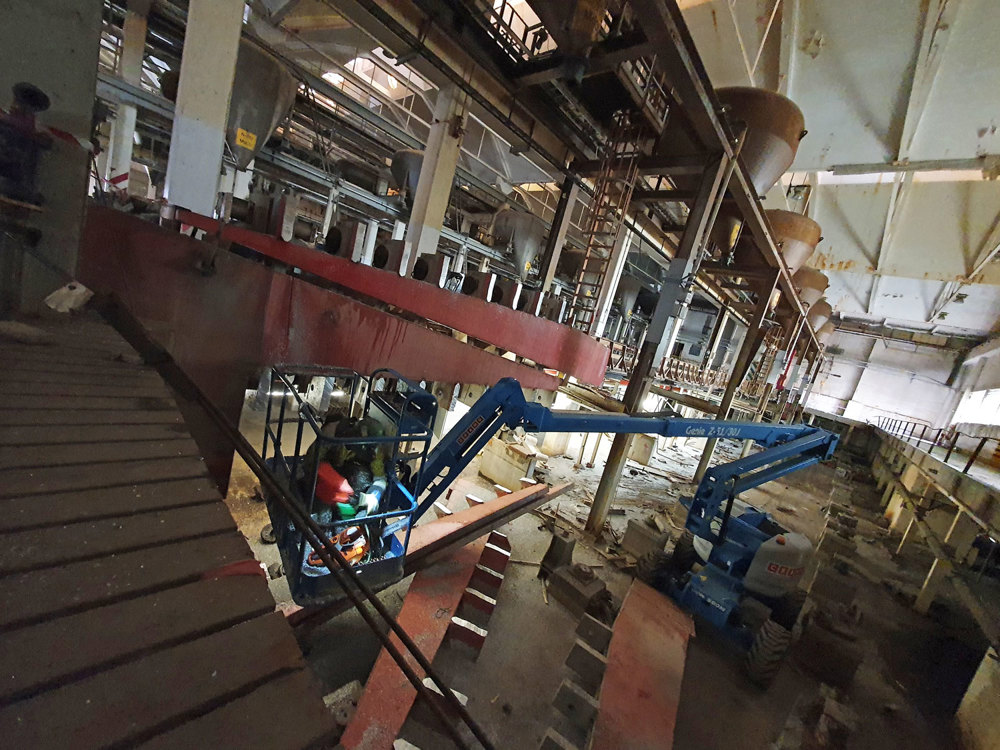 fabrikkhall med lift og mannskap som demonterer aluminium