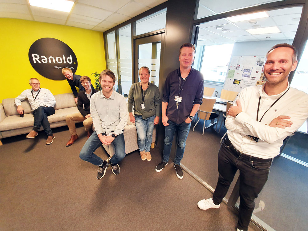 seven employees standing and sitting in new offices