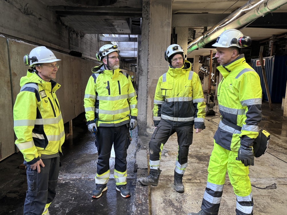 four men talking, basement, concret building, pillars
