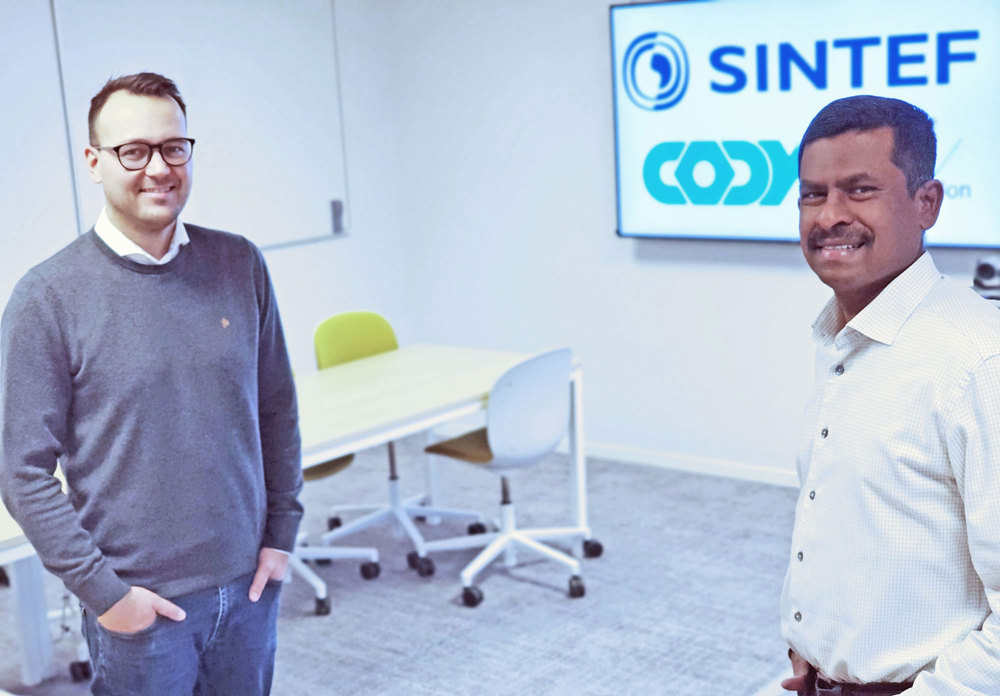 Two men standing in meeting room