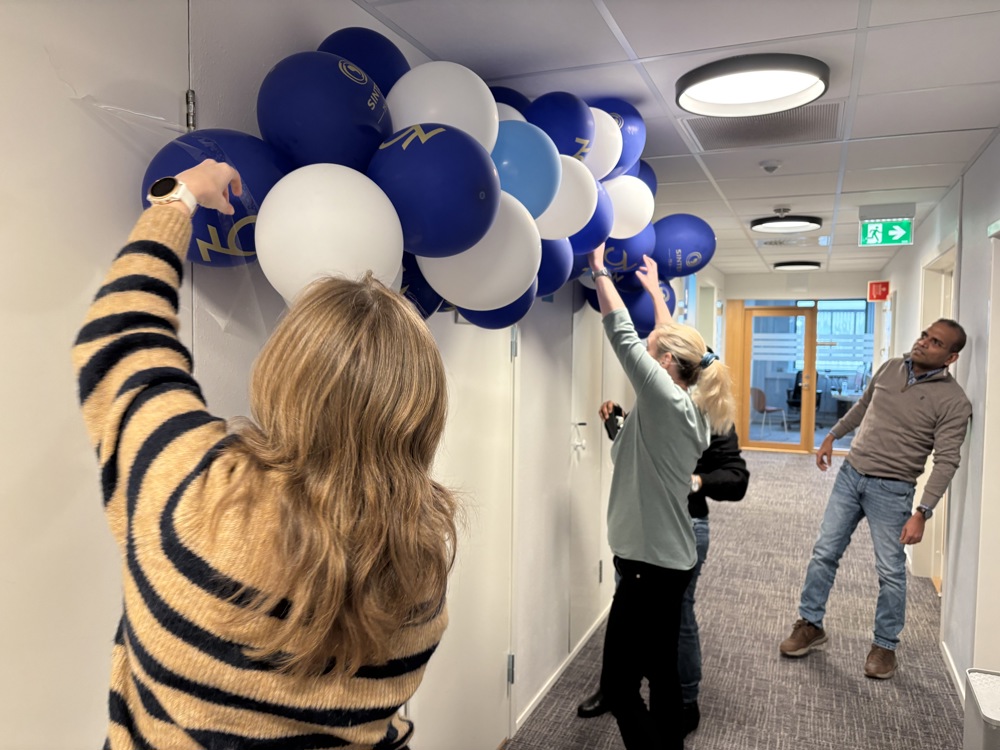 balloons, office space, three persons attaching balloons to the ceiling