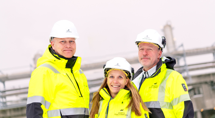 gruppebilde, to høye menn, kvinne i midten, ute