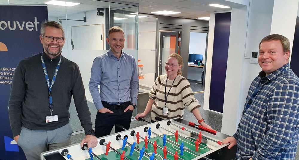 four people standing by a footballgame table