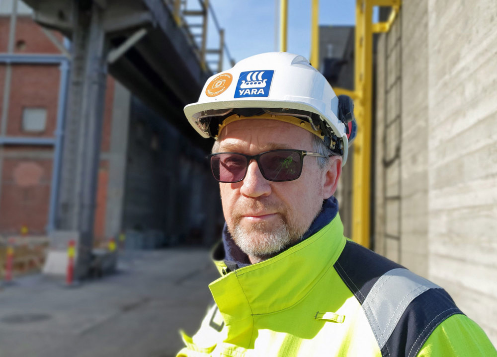 portrait of man, standing close to concrete wall, industry