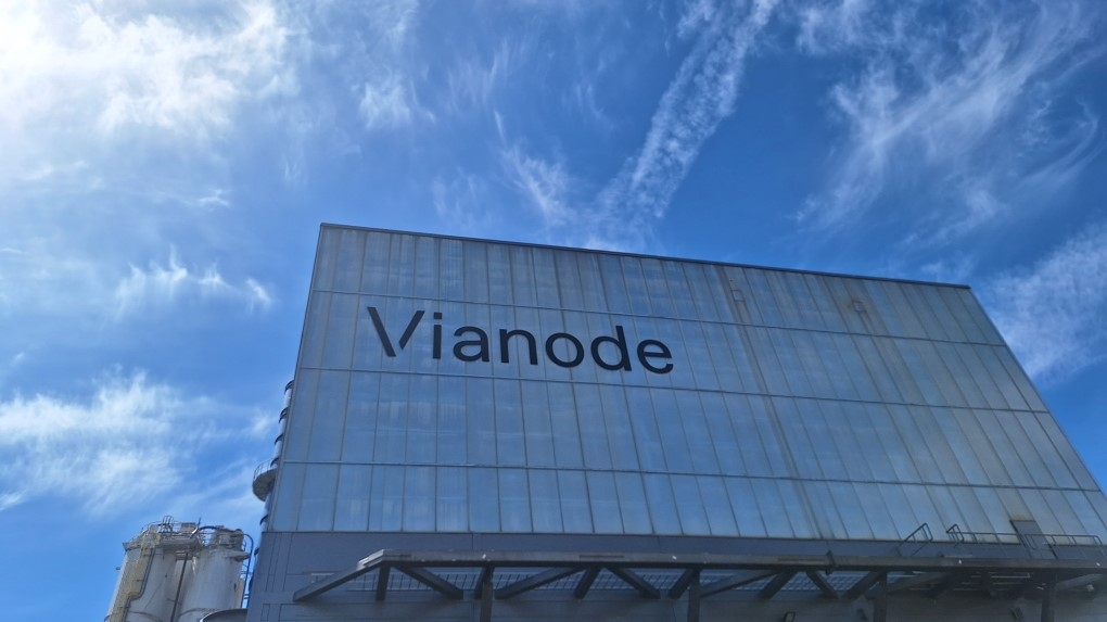 industrial building, logo in big letters on the wall, blue sky above building