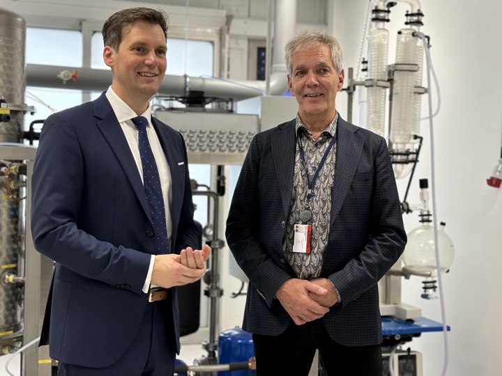 two men, talking together, both wearing blue suits, special occation, pilot facility