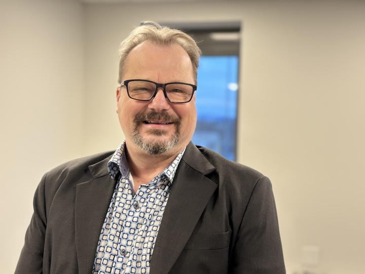 portrait of man, posing, glasses, blazer, office corridor, window in background