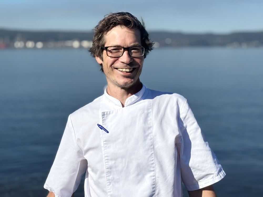 portrait of man, white clothing, posing, smiling, glasses