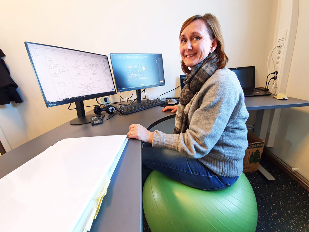 female colleague sittin on a medicine ball at her desk in office